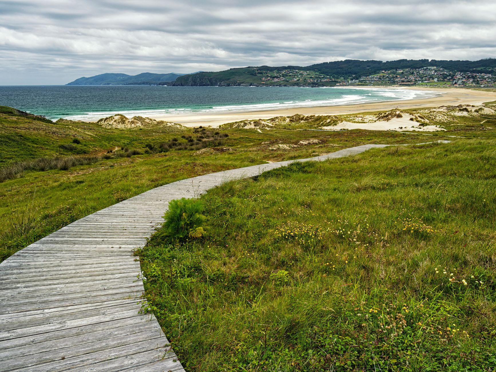 Passerelle en bois sur milieu dunaire littoral, intégrée à la végétation